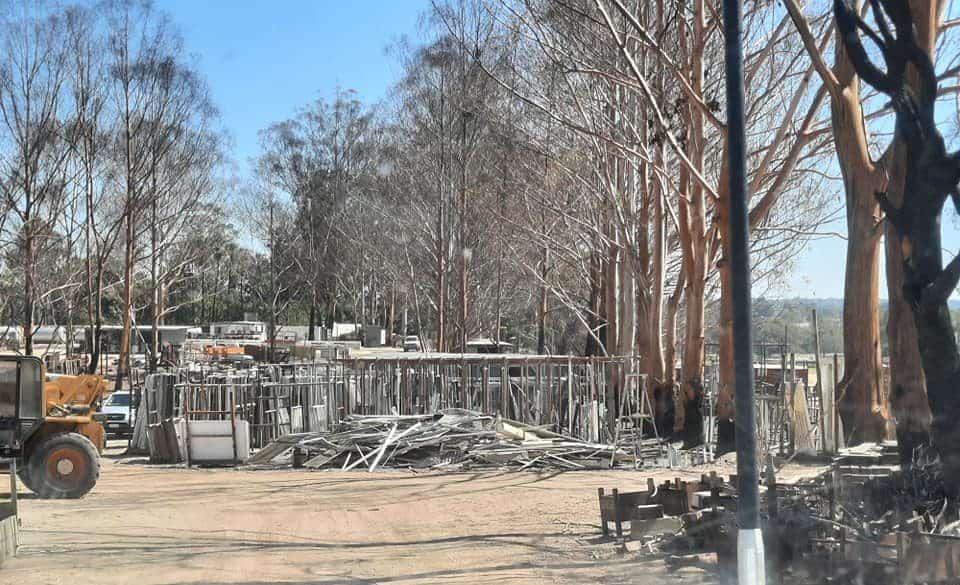 Salvage Yard with excavator machine and a pile oof metals, bricks and woods