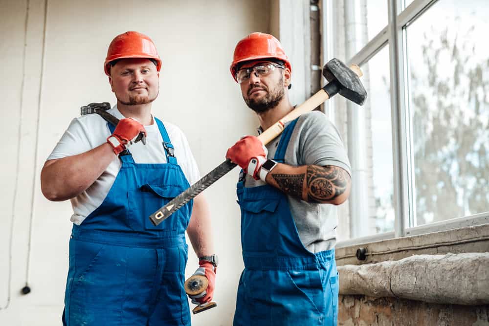 A group of men for Demolition & Salvage wearing hard hats and holding hammers