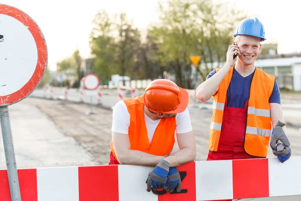 A group of Demolition & Salvage experts wearing hard hats and orange vests for demolition project